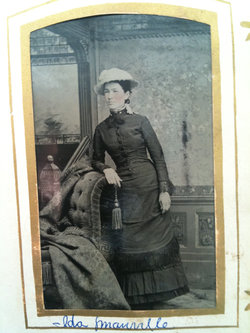 A black and white portrait of Reverend Ida Manville, a white woman. She stands while leaning her arm on a couch and is wearing a dark dress, a light-colored hat, and holding a bag in her hand. Her name is printed on the bottom of the image.